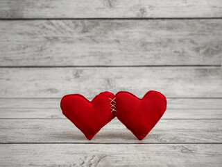 Two red hearts tightly sewn together. Valentine's Day background. The heart of love. Place for text