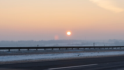 Winter landscape in snow nature with sun, field and trees. Magical winter sunset in a snow field.
