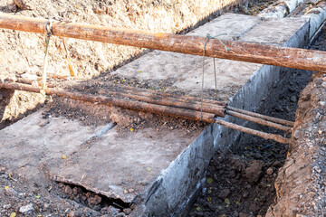 Construction works on large iron pipes at a depth of excavated trench