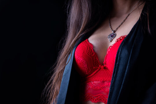 bust breasts of a girl in lingerie and a robe red bra with decoration pendant necklace