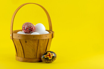 Traditional Pysanka - vintage Ukrainian Easter eggs along with a basket full of plain white eggs.