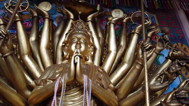 Revered golden statue of Guanyin Buddha (Avalokiteshvara) at the ancient Wat Phanan Choeng temple in Ayutthaya, Thailand.