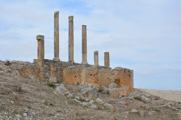 Ruins of  the ancient roman city of Dougga in modern Tunisia, Africa. Blue sky with clouds, white,...