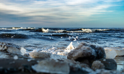 Sea wave splash and foam near shore. Ice in the coast. winter. copy space