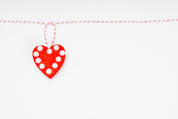 Template on the theme of valentine's day, romantic letterhead for cards, invitations, copy space.Valentine s day concept.Red heart with beads hanging on a thread on a white background.