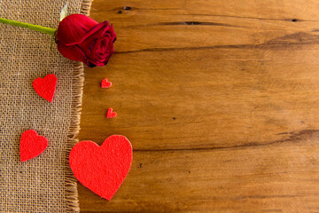 Fototapeta premium Valentine's Day concept, hearts and rose on wooden table.