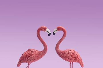 Love in the air minimal concept. Two toy flamingos looking in each other. Modern very peri background.