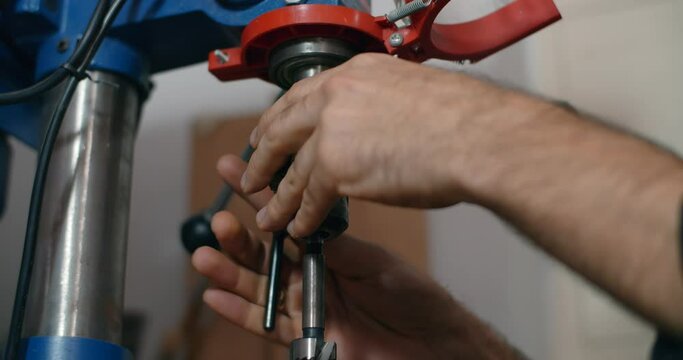 Woodworker change drill in the drilling machine in slow motion, carpentry at workshop, bore the holes, mechanical processing of timber, 4k DCI 60p Prores 422 HQ 10 bit