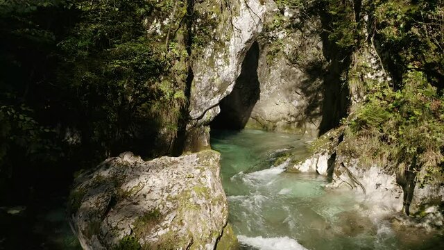 Push Out Revealing Shot of Beautiful Turquoise, Emerald River Floating Out of Big Gorge Surrounded With Forest Plants on The Walls and Stones. Predaselj, Kamni&scaron;ka Bistrica, Slovenia.
