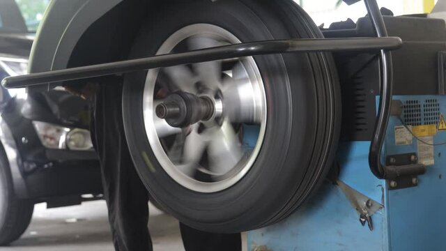 Wheel balancing or repair and change car tire at auto service garage or workshop by mechanic