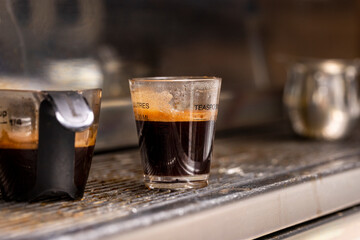 Expresso machine and coffee shots being processed for a drink at a Coffee house.
