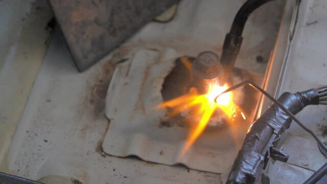 Welding torch with argon-arc and flame on car door