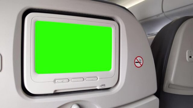 White LCD Screen in an Airplane Seat Turning On Chroma Key Green Screen. Zoom In. Close Up.