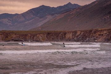 Surfers Off the Coast of California along Pacific Coast Highway at Sunset