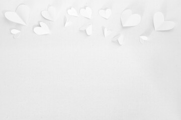 For Valentines Day or wedding, invitation with small cut out white hearts on white canvas background, copy space