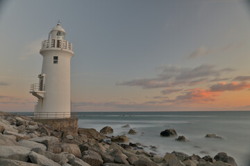 海辺の灯台と夕陽写真、スローシャッター撮影