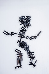 Silueta de una persona, formada por letras negras de plástico usadas para letrero luminoso