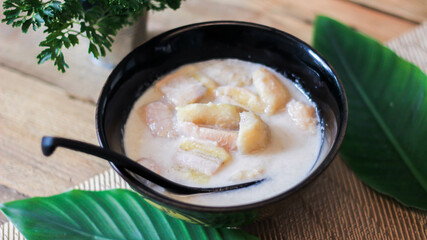 Banana in Coconut Milk on wood table Traditional dessert of asian, Thailand.