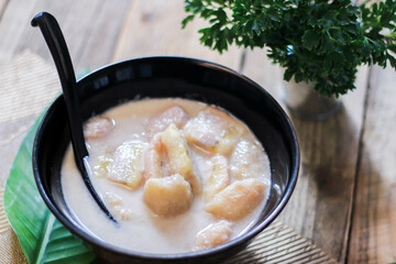Banana in Coconut Milk on wood table Traditional dessert of asian, Thailand.