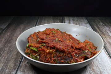 Traditional spicy curry paste seasoning with fried fish serving in the bowl. Famous hot and spicy seafood menu in Asian restaurant. 