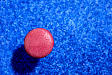 delicious sweet dessert pink berry macaroon on a blue shiny background. close-up