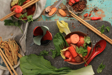 Top View Spicy Thai Tom Yum Soup with Seafood, Served on Rustic Brown Bowl, on Green Wooden...