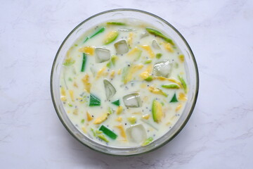 a bowl of  iced mix fruit and milk against white background 