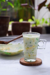 selective focus of iced mix fruit and milk in a glass against nature background 