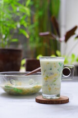 selective focus of iced mix fruit and milk in a glass against nature background 