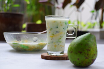 selective focus of iced mix fruit and milk in a glass against nature background 