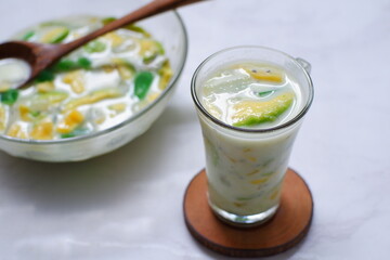 selective focus of iced mix fruit and milk in a glass against nature background 
