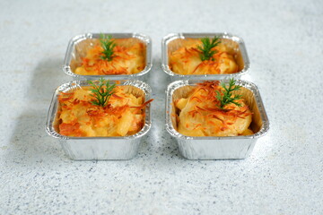 selective focus of  baked macaroni and cheese  in aluminium foil cup against white background 