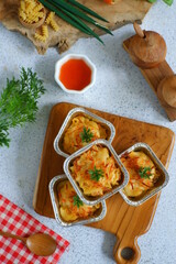 selective focus of  baked macaroni and cheese  in aluminium foil cup against white background 