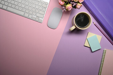 Above view wireless keyboard, coffee cup and supplies on purple background.