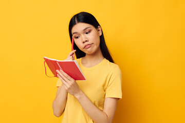 Portrait Asian beautiful young woman writes in a notebook with a pencil isolated background unaltered