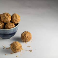 Peanut butter, sunflower seed and date energy balls on a white background. 