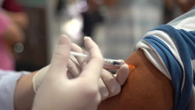 Covid-19 vaccine injection by doctor at hospital. A doctor, nurse injecting coronavirus remedy into an elderly people arm.