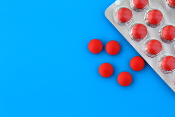 A pile of medicines in the form of pill sizes and lie on a blue background.