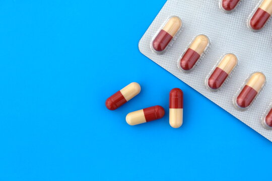 Medicine in capsules and in a tablet on a blue background