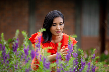 Naklejka premium beautiful woman with red shirt taking care the flower