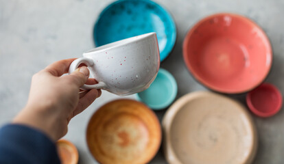 Ceramic plates and cup on wooden surface. Overview empty food table with tableware. 