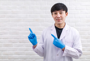 Portrait studio shot Asian professional male scientist in white lab coat rubber gloves standing...