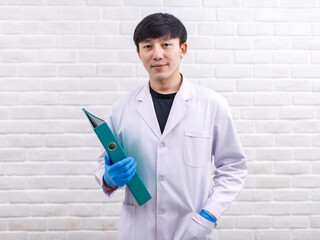 Portrait studio shot Asian professional male scientist in white lab coat rubber gloves standing...