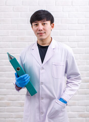 Portrait studio shot Asian professional male scientist in white lab coat rubber gloves standing...