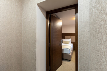 Fototapeta na wymiar View to a hotel bedroom, open wooden door