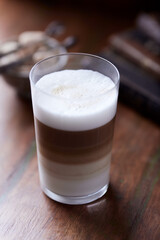 Coffee with milk on wooden background. Soft focus. Close up.