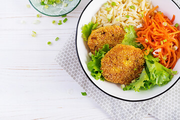 Orzo pasta, carrots and chicken burgers in white bowl. Risoni pasta. Lunch. Top view, above, copy space