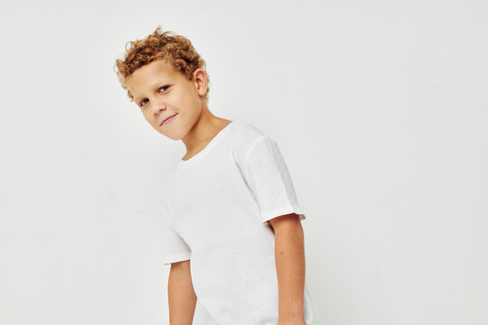 Cute little boy in a white t-shirt posing fun isolated background
