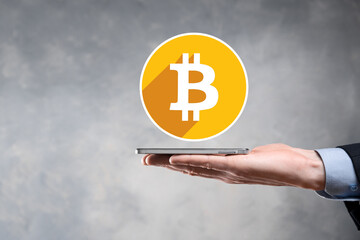 Male hand holding a bitcoin icon on grey background. Bitcoin Cryptocurrency Digital Bit Coin BTC Currency Technology Business Internet Concept