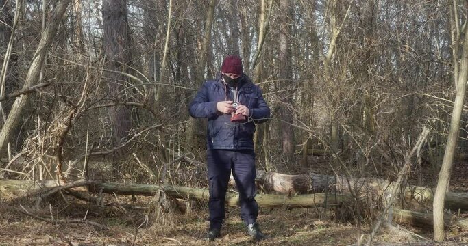 a man in a pine forest takes pictures on a retro camera